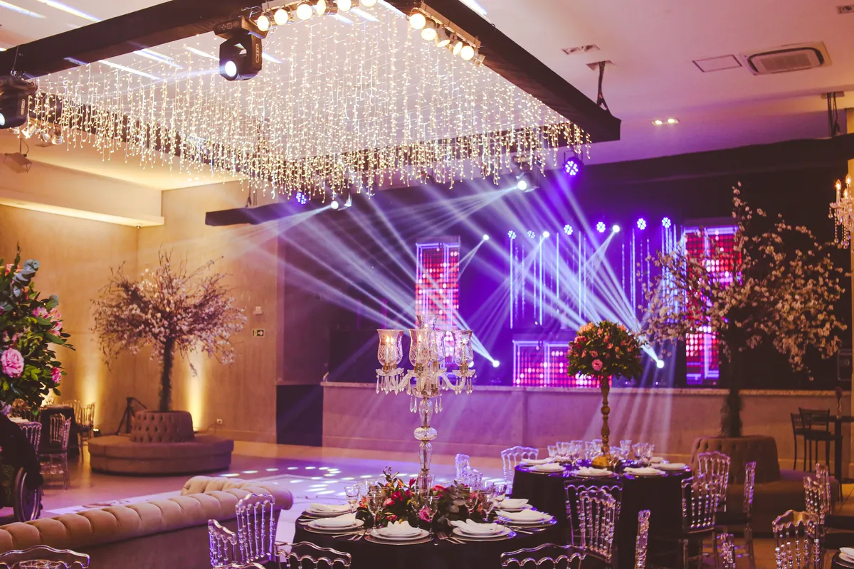 Een zaal met podiumlicht en zicht vanaf de dinertafels.